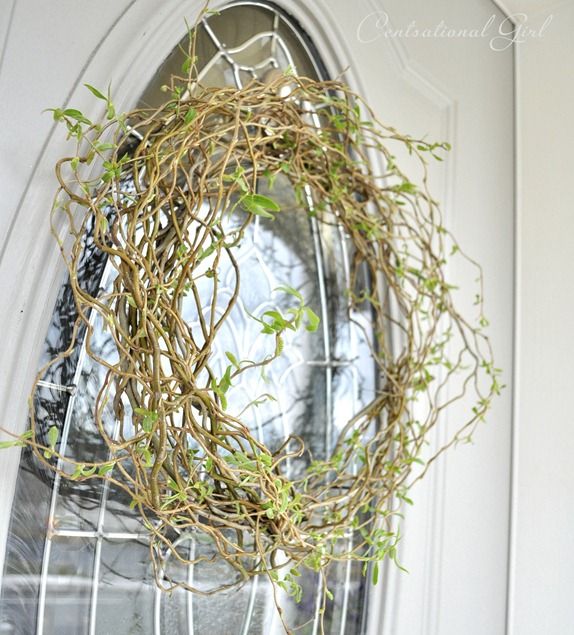 a wreath hanging on the front door of a house with vines growing out of it