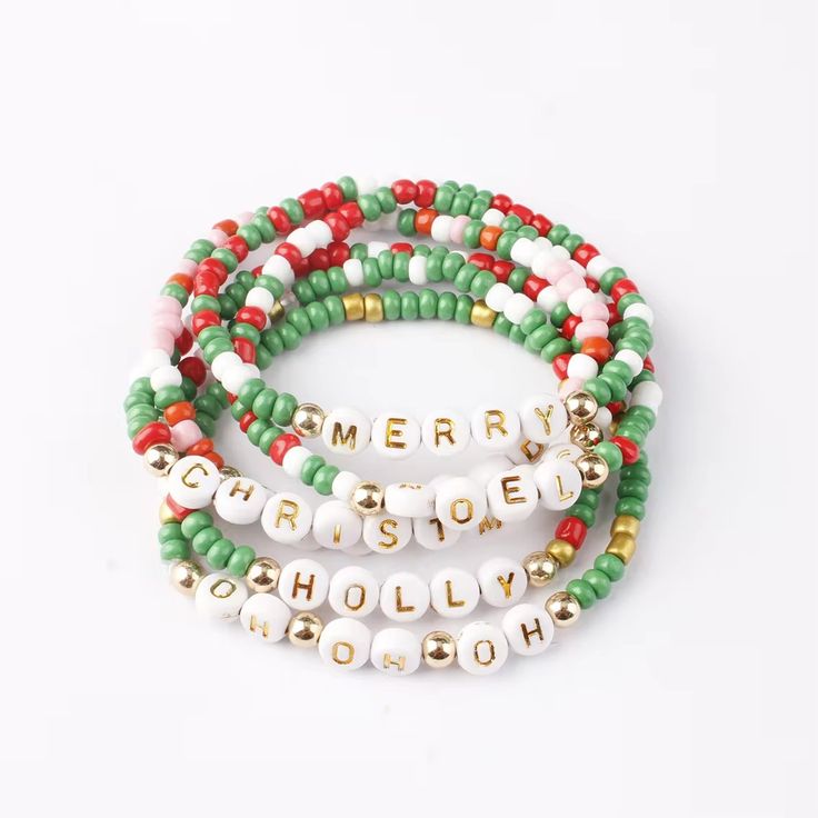 three bracelets that say merry christmas spelled in gold, white and green beads with words on them