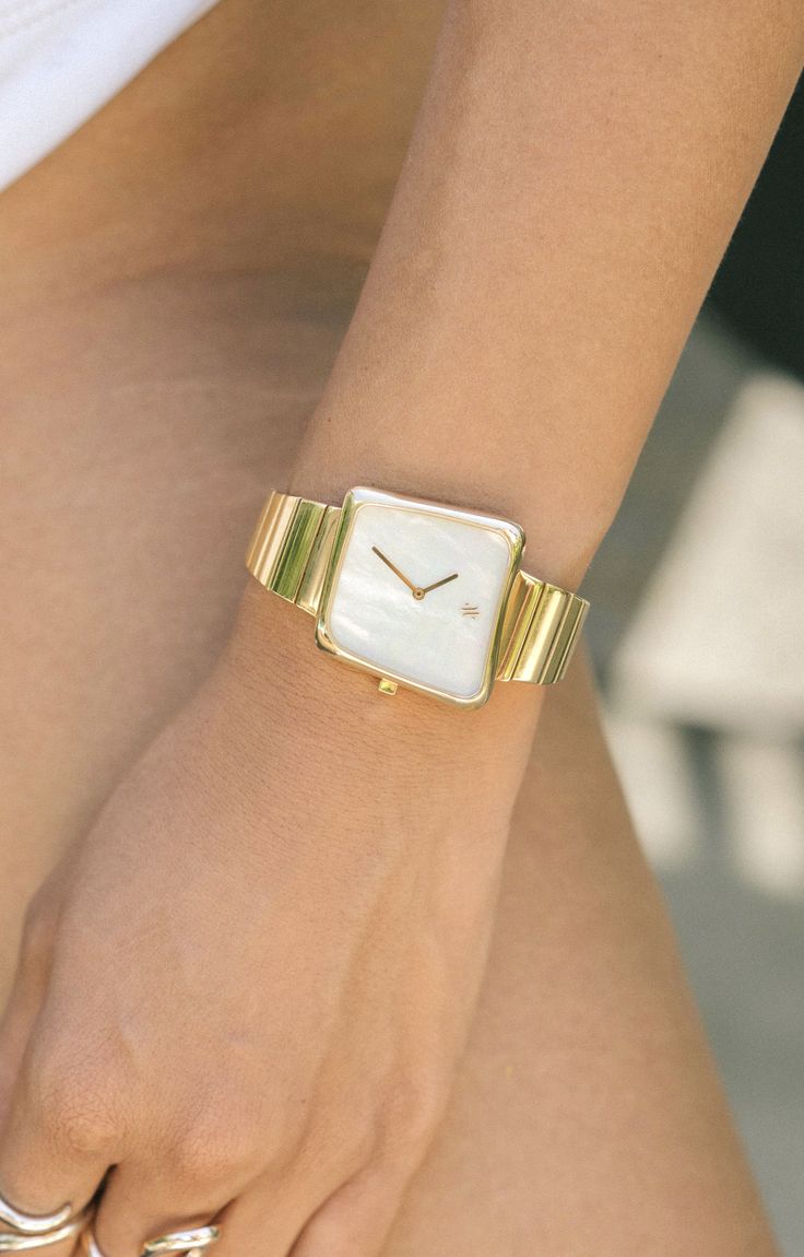 The asymmetric case of Nebula was inspired by gas clouds in space which are devoid of specific shape or form. The genuine white mother of pearl dial beautifully contrasts the polished gold bracelet. Gold Minimalist Watch With Bracelet Strap, Elegant Gold Watches With Subdials, Minimalist Gold Watch With Bracelet Strap, Modern Gold Jewelry And Watches, Elegant Gold Watch With Polished Finish, Chic Gold Everyday Watch, Chic Everyday Gold Watches, Gold Watches With Diamond Hour Markers For Everyday Luxury, Chic Gold Watch With Rectangular Dial