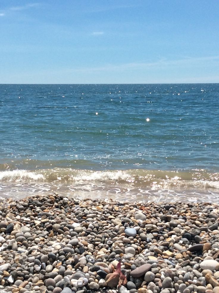 there are many rocks on the beach near the water