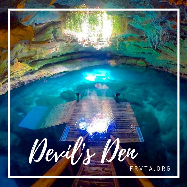 the inside of a cave with blue water and stairs leading up to an entrance into it