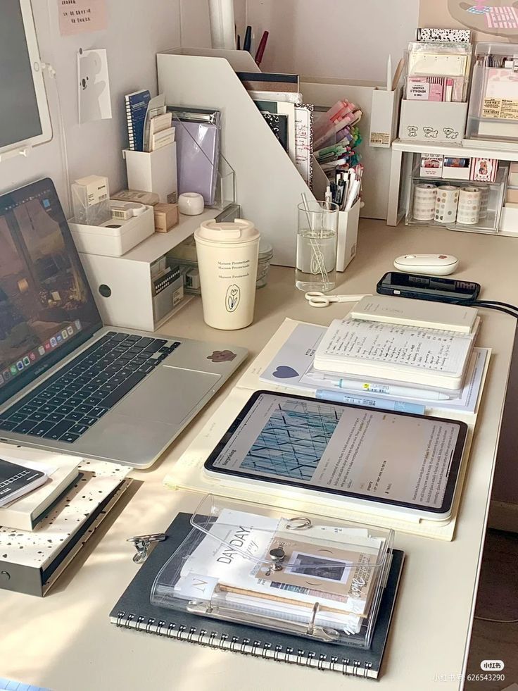 an office desk with two laptops and several books on it