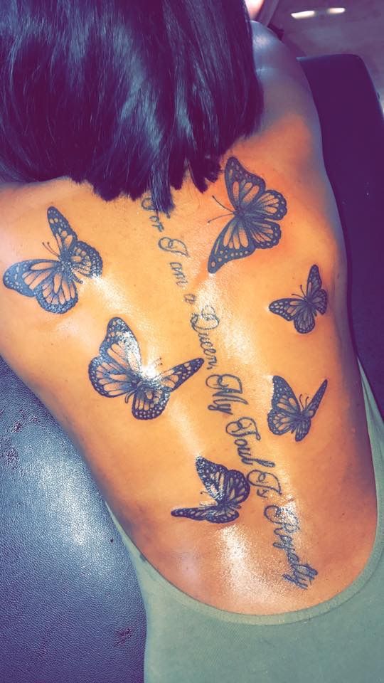 the back of a woman's body with butterflies on it and words written in cursive writing