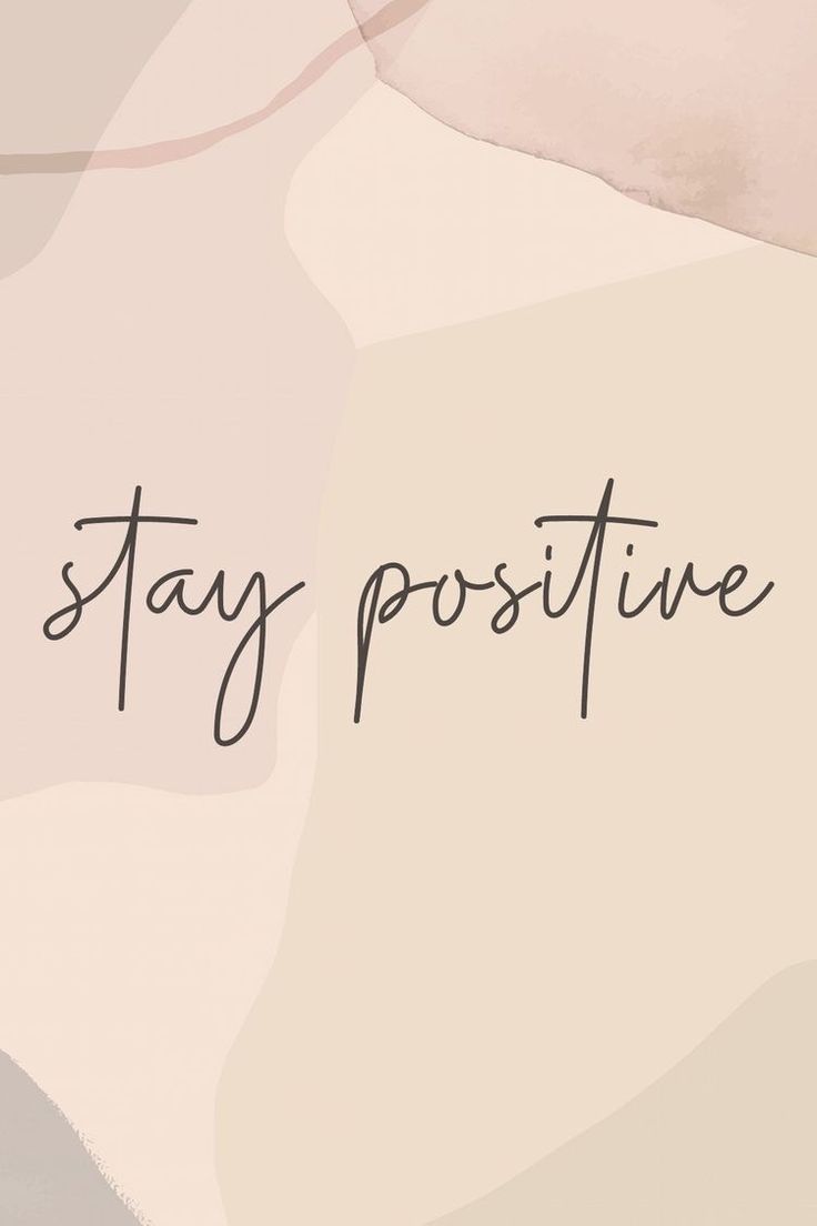 the words stay positive written in black ink on a pink and gray background with an abstract pattern