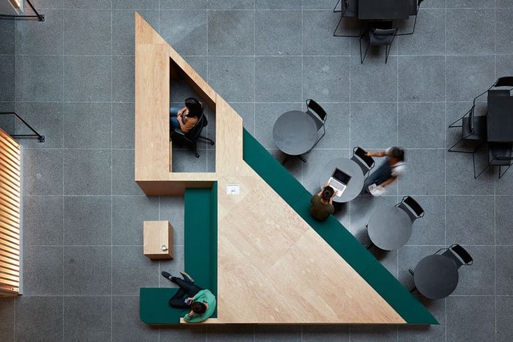 a woman is sitting on the floor next to a table and chairs in an office