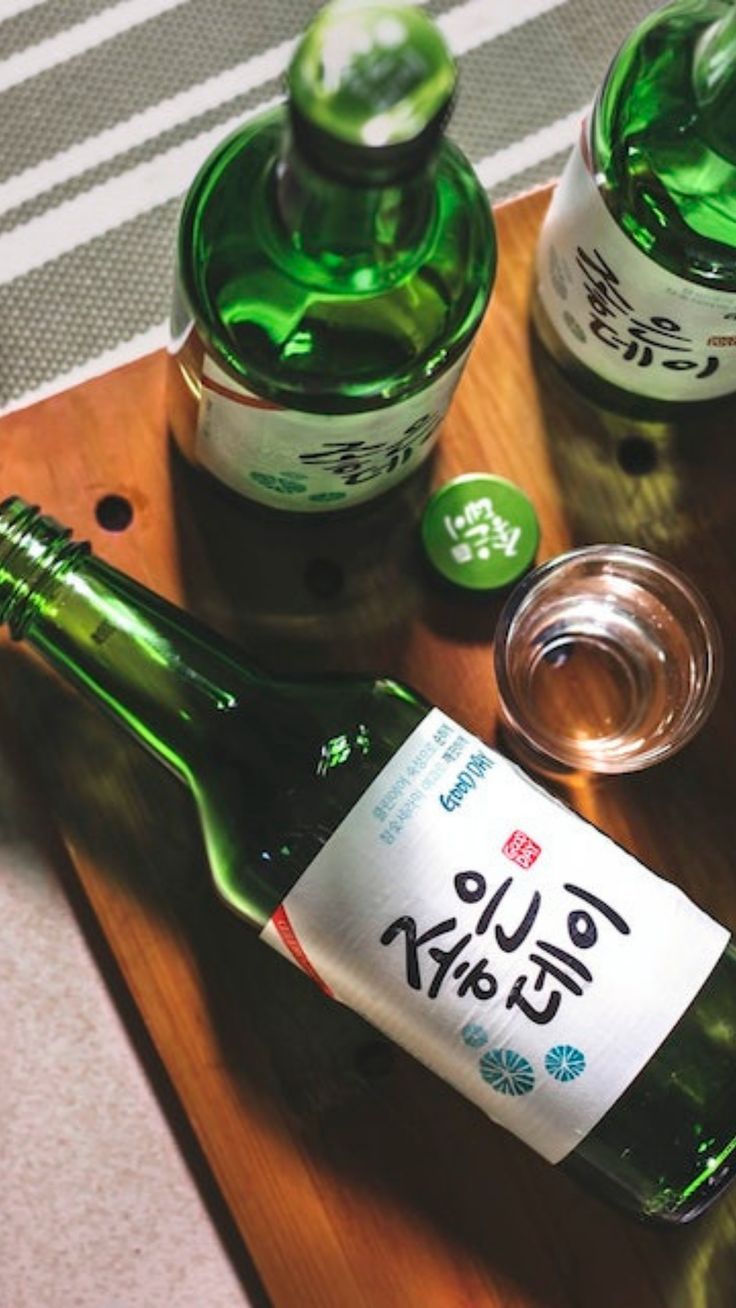 two bottles of alcohol sitting on top of a wooden tray