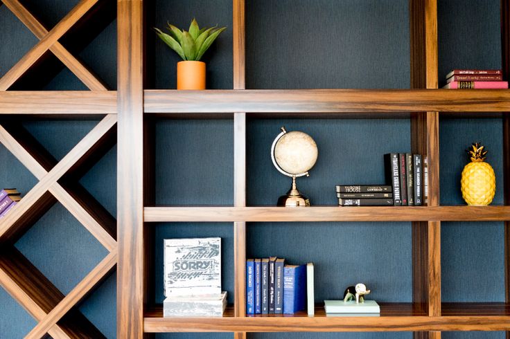 a bookshelf filled with lots of different types of books next to a pineapple