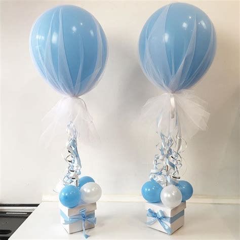 two blue and white balloons are attached to small gift boxes with ribbons, bows and streamers