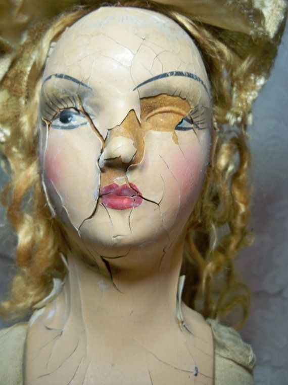 an old doll with broken face and hair