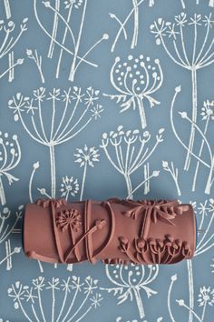 a chocolate candy bar with the word love on it sitting in front of a blue floral wallpaper