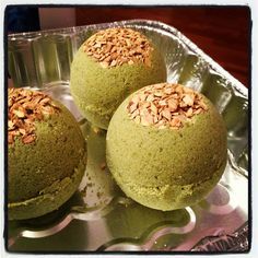 three balls of green cake with nuts on top