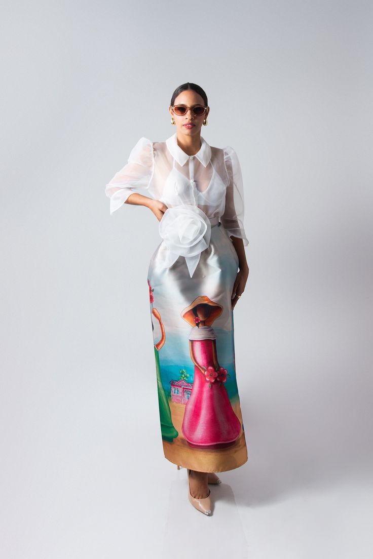 Flor de Caribe is a stunning long skirt crafted from luxurious mikado fabric, known for its rich texture and subtle sheen. The skirt features a full and graceful A-line silhouette, draping elegantly from the waist to the floor. Its standout detail is inspired by the traditional faceless dolls of the Dominican Republic. The artwork depicts these iconic figures, symbolizing Dominican heritage and culture, with soft, flowing lines and vibrant colors that stand out against the smooth surface of the Dominican Faceless Dolls, Elegant Floor-length Satin Skirt, Chic Silk Full Maxi Skirt, Spring Formal Floor-length Skirt, Spring Formal Silk Maxi Skirt, Spring Evening Silk Maxi Skirt, Formal Summer Satin Maxi Skirt, Chic Silk Skirt For Wedding, Spring Evening Silk Skirt