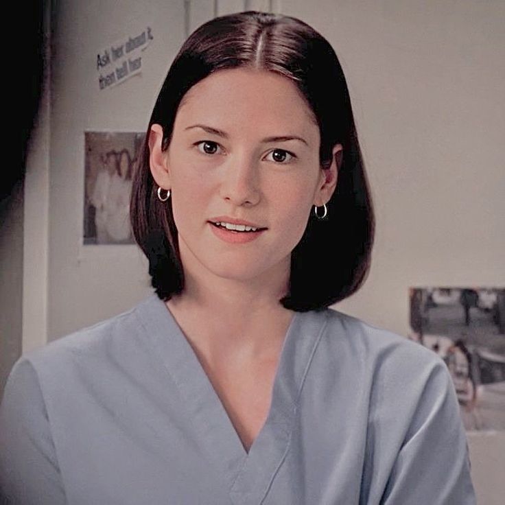 a woman in scrubs is looking at the camera