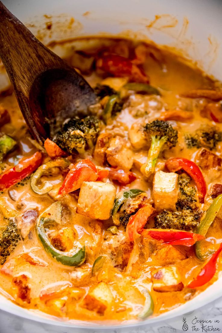 a wooden spoon in a bowl filled with food