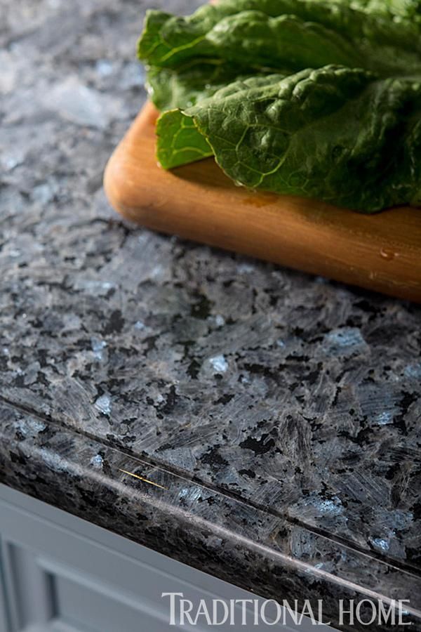 lettuce sitting on top of a wooden cutting board next to a granite counter