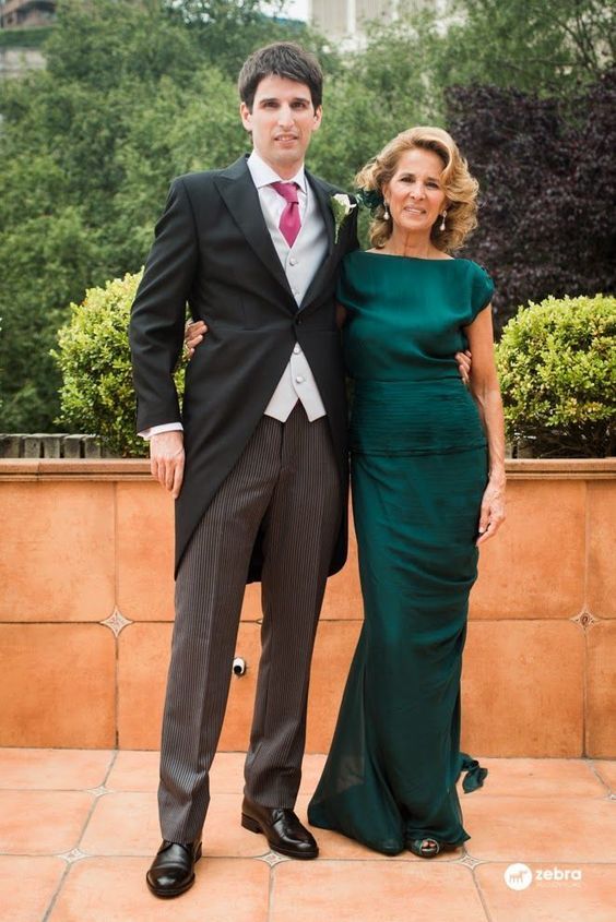 a man and woman standing next to each other in formal wear posing for the camera