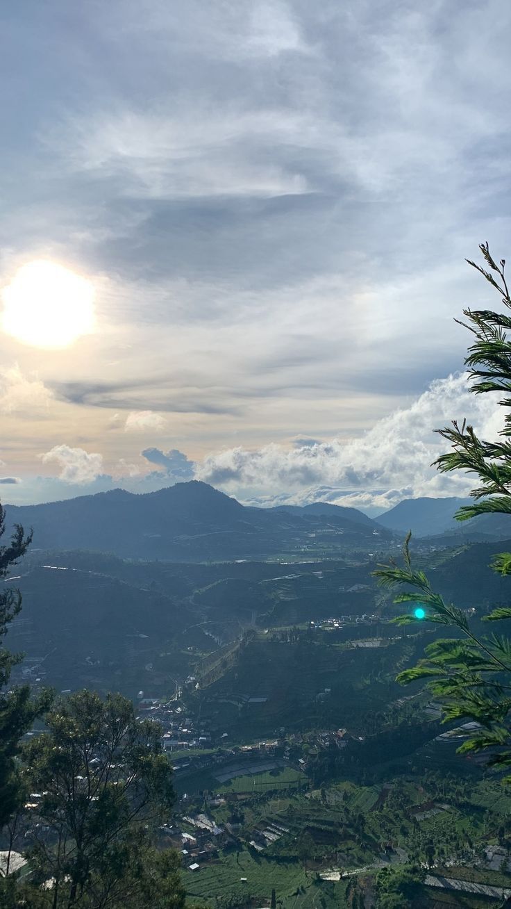 the sun shines brightly through the clouds in the distance, with mountains in the background