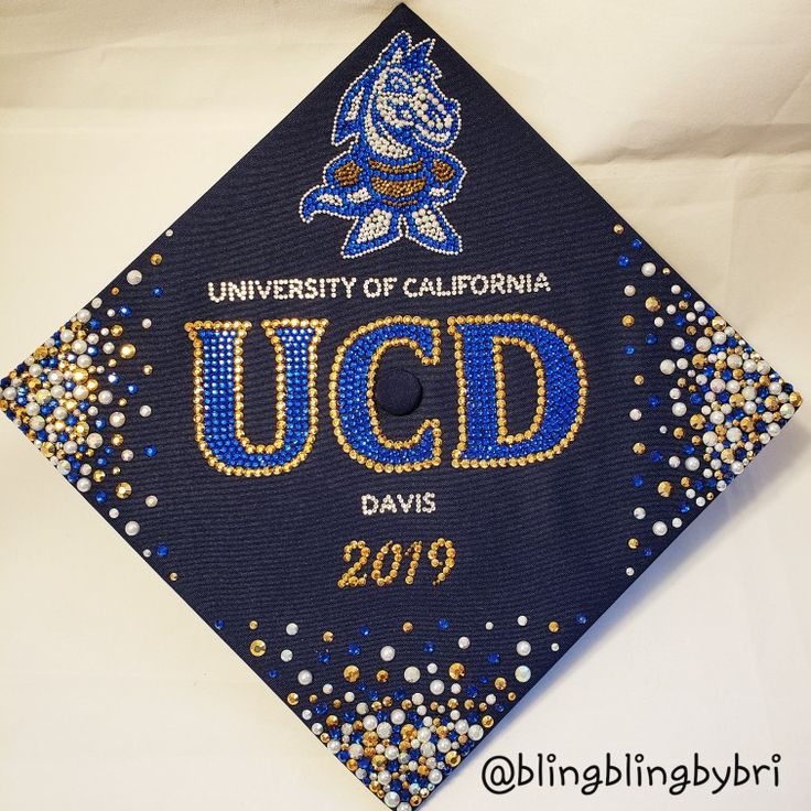 a blue graduation cap with the university of california ucd davis logo on it and gold sequins