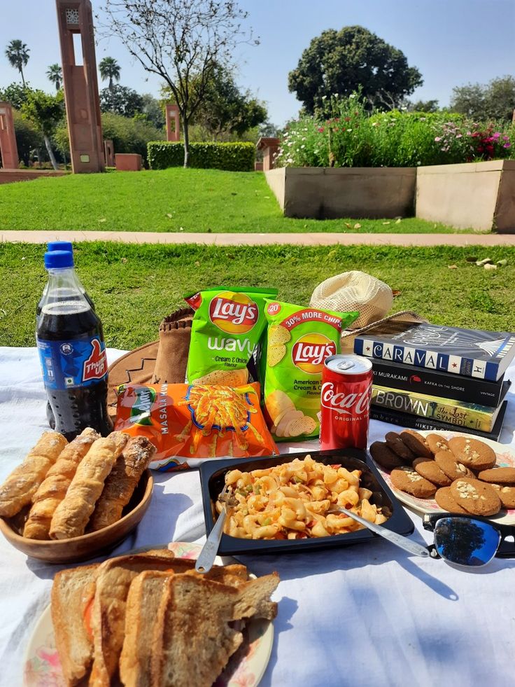 a picnic table with snacks and drinks on it