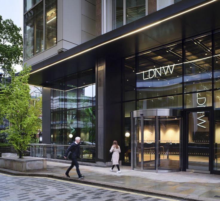 two people are walking past a luxury store