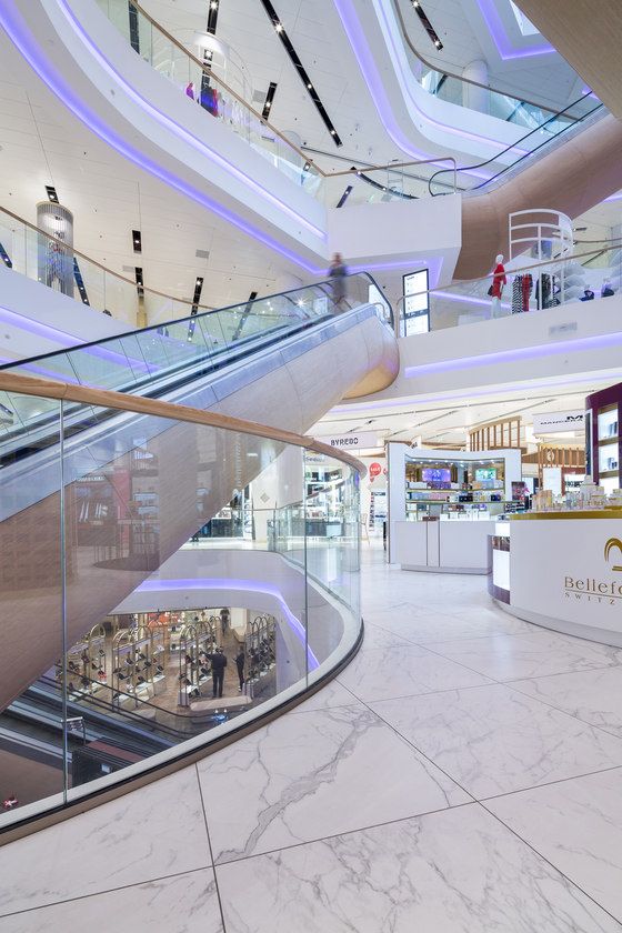 an escalator in a shopping mall with people walking up and down the stairs