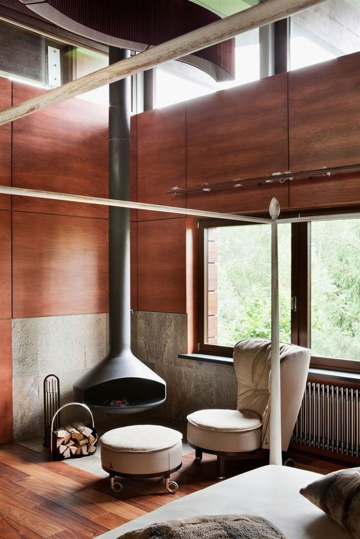 a bedroom with wood paneled walls and a fireplace in the corner next to a bed