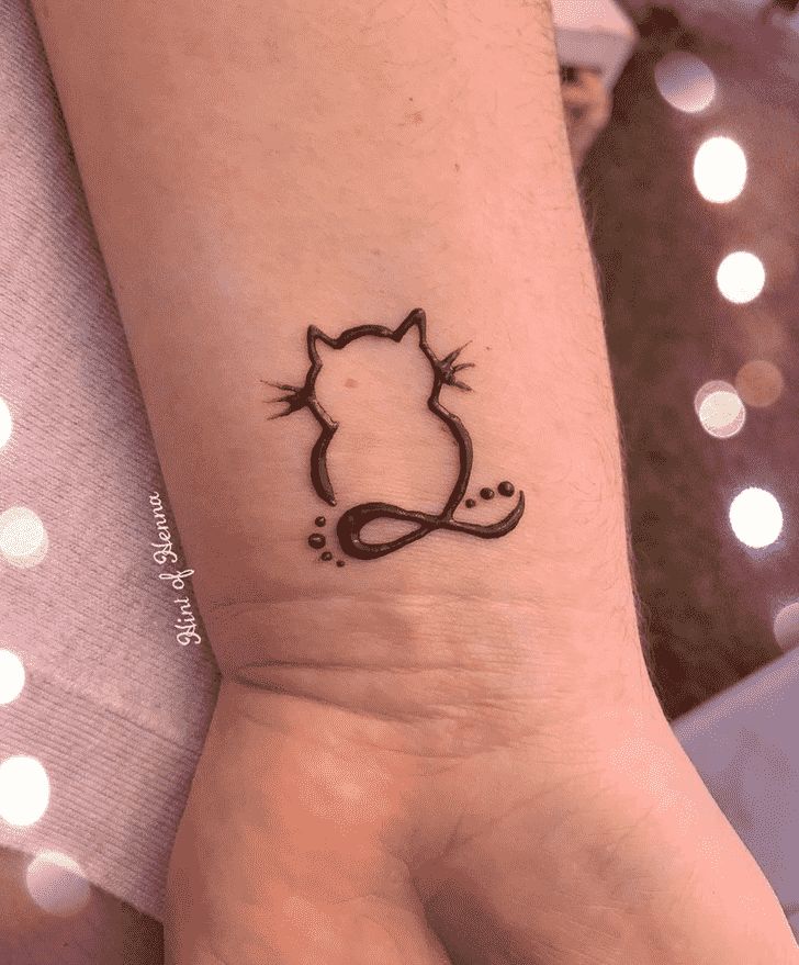 a small tattoo on the wrist of a person with a cat design on it's arm