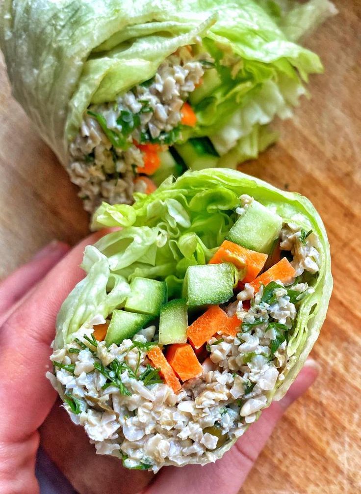 two lettuce wraps with carrots, cucumbers and other veggies