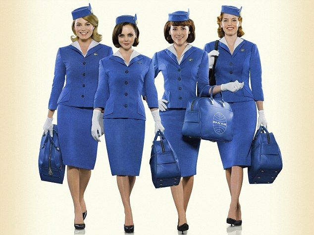 three women in blue uniforms holding bags and purses