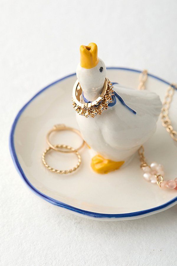 a white bird with a gold crown on it's head sitting on a blue and white plate