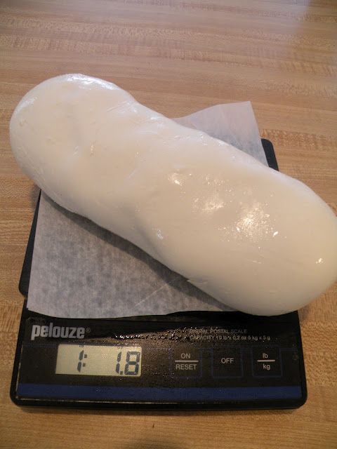 a large piece of bread sitting on top of a scale next to a digital clock