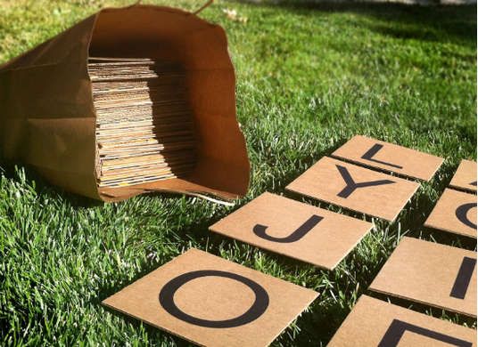 several pieces of cardboard sitting on top of grass with the word joy spelled in black