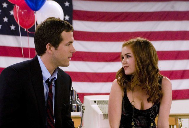 a man and woman sitting next to each other in front of an american flag