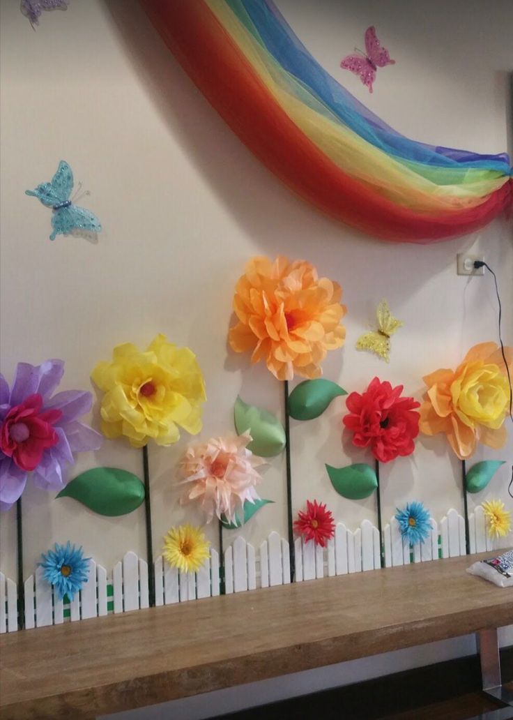 colorful paper flowers are arranged on the wall