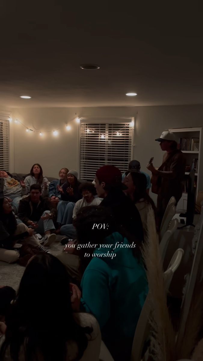 a group of people sitting on the floor in a living room with lights above them