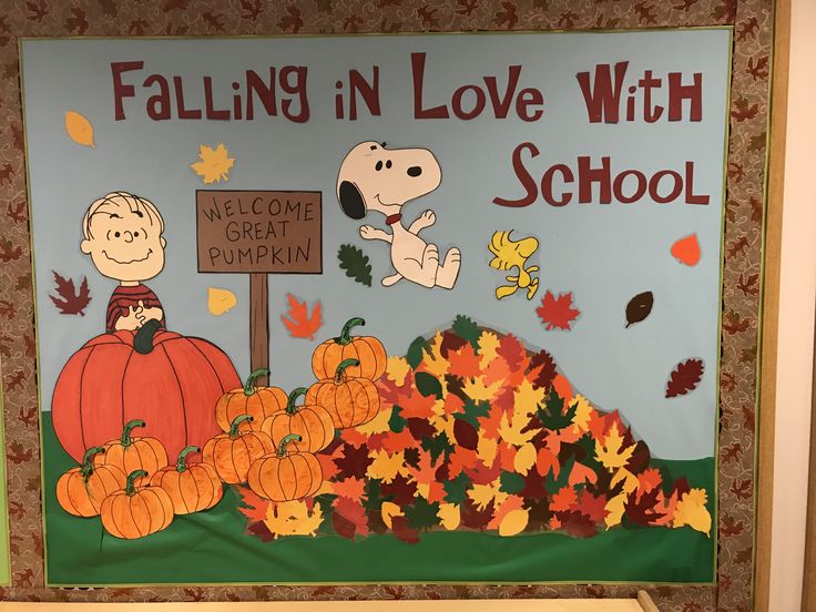 a bulletin board with peanuts, pumpkins and leaves on it that says falling in love with school