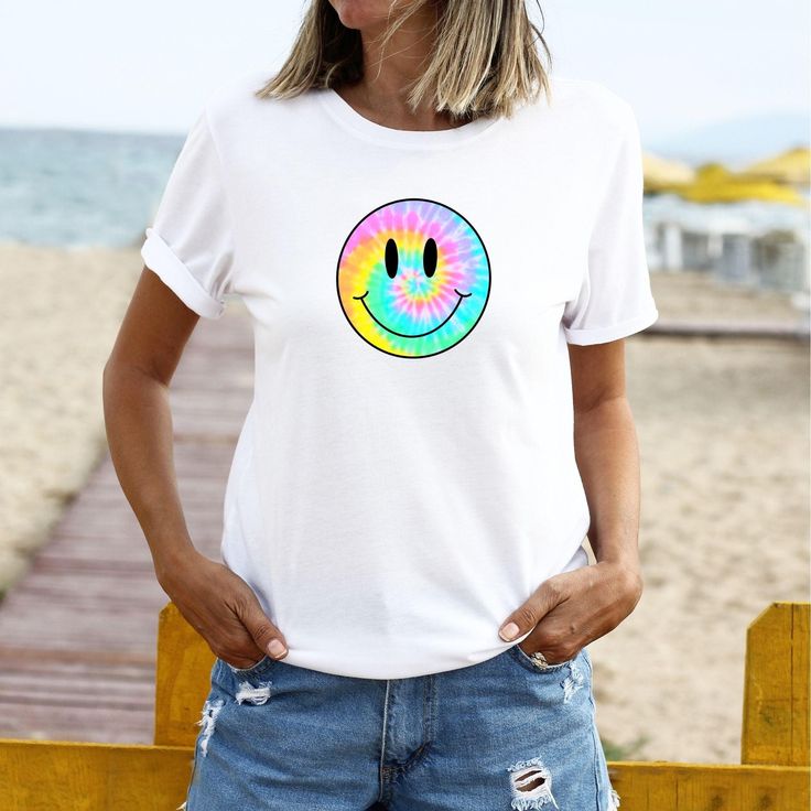 Tie-Dye Smiley Face Retro Aesthetic T-Shirt ﻿The model is wearing white. Despite every effort to provide accurate images of each product and design the colors may vary slightly, due to different device screen settings and photography lighting. Please be aware that our clothes are not oversized. If you desire an oversized look we recommend ordering 2-3 sizes larger than how you size on our size guides. Classic Fit 100% Cotton Preshrunk jersey knit Seamless double-needle 7/8" collar Taped neck and Summer Tie Dye T-shirt With Funny Print, White Printed Casual T-shirt, Casual White Printed T-shirt, Fun White T-shirt With Sublimation Print, Trendy Tie Dye T-shirt With Graphic Print, Casual Tie-dye Printed T-shirt, Casual Tie Dye Printed T-shirt, Casual Printed Tie Dye T-shirt, Trendy White Printed T-shirt