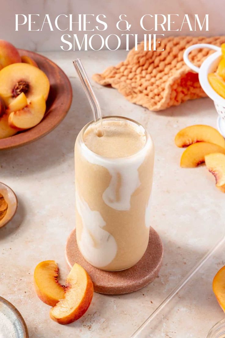 peaches and cream smoothie in a glass on a table with sliced peaches