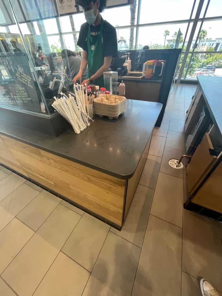 a person standing at a counter in a restaurant with lots of utensils on it