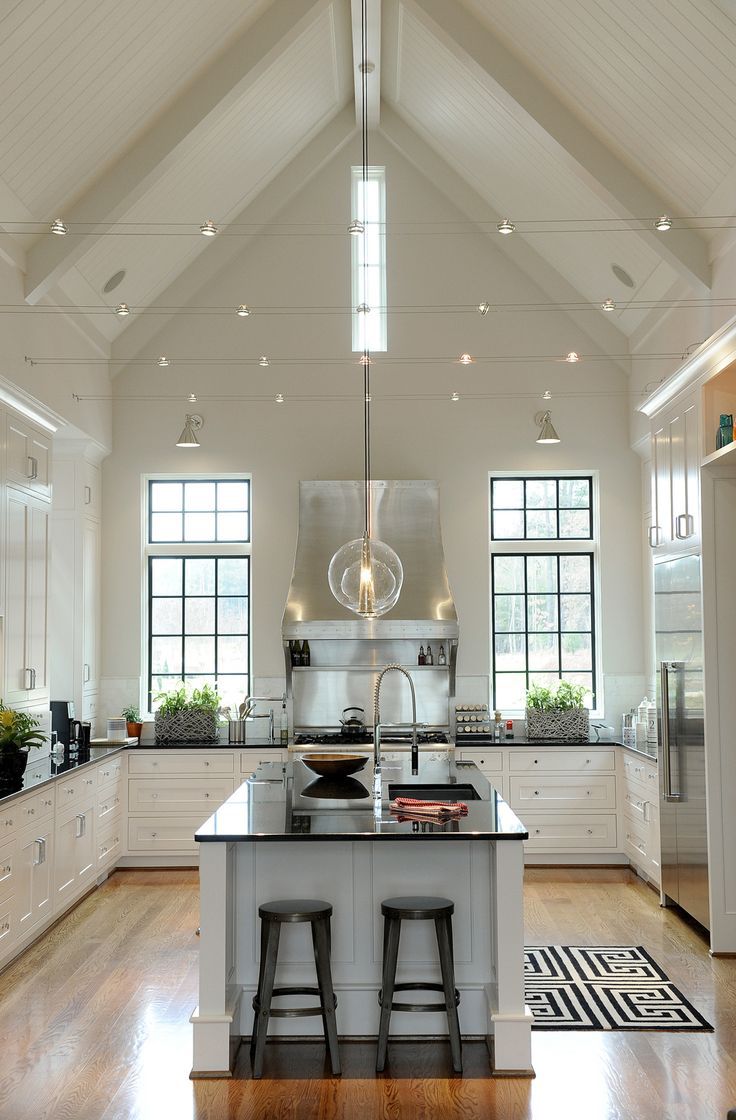 a large kitchen with two stools in front of the center island and an open floor plan