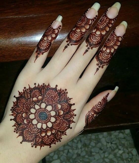 a woman's hand with henna tattoos on it