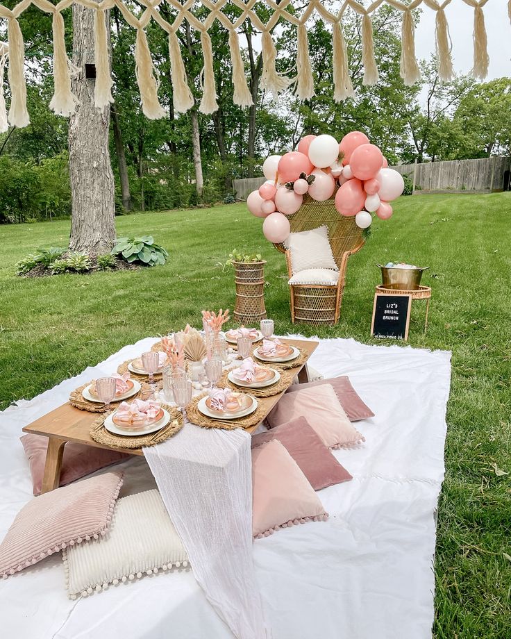 a table set up with pink and white balloons