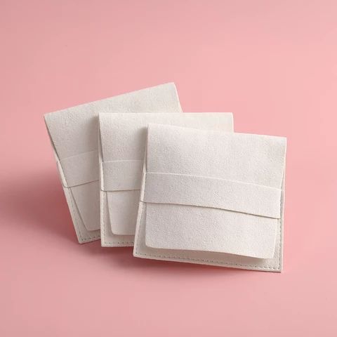 three white towels folded on top of each other in the shape of rectangles