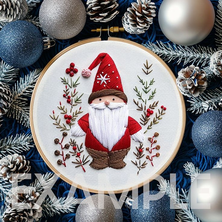 a cross stitch santa clause with pine cones and ornaments around it on a blue background