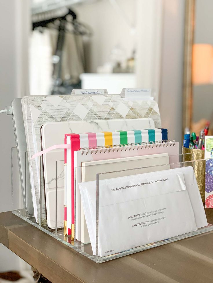 several folders and pens are sitting on a desk with a mirror in the background