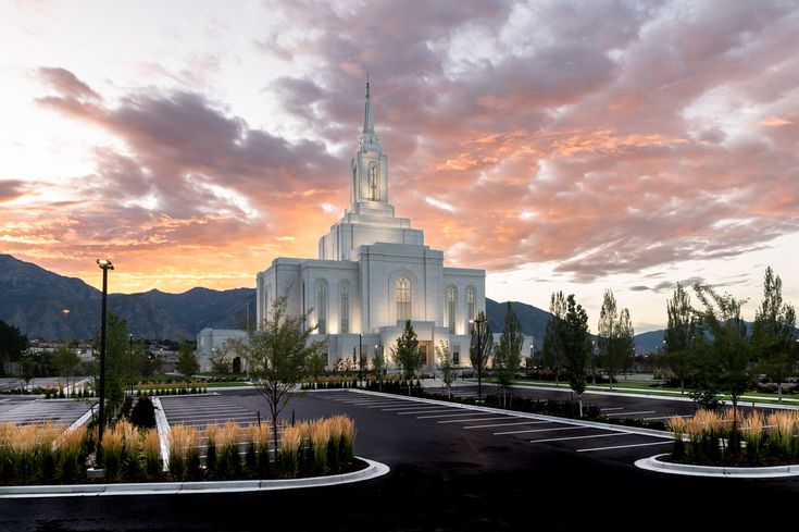 a large white building with a steeple at sunset