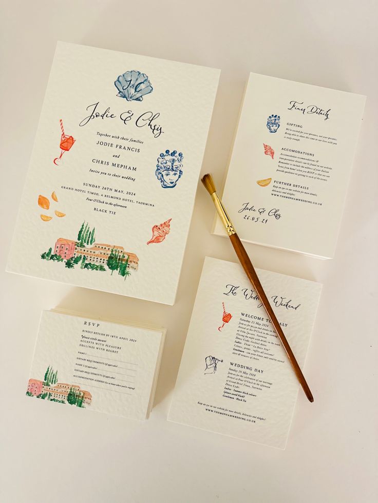 the wedding stationery is laid out on top of each other with a brush next to it