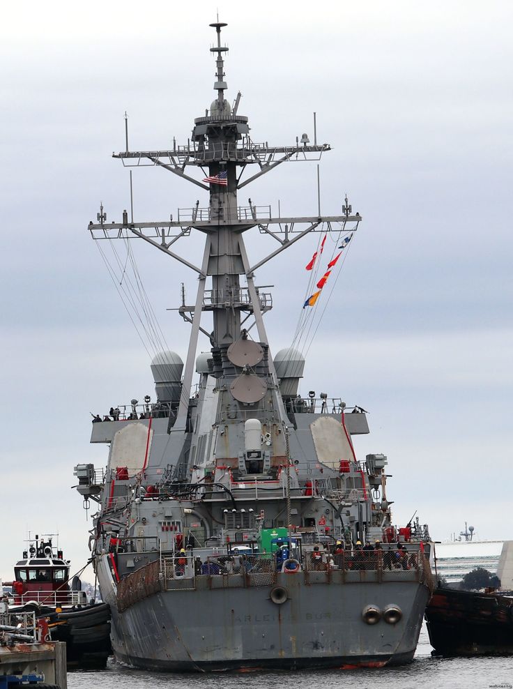 a large battleship sitting in the water next to other boats