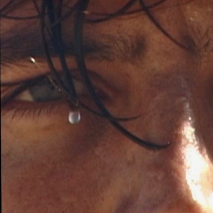 a close up of a person's face with water drops on their forehead and eyes