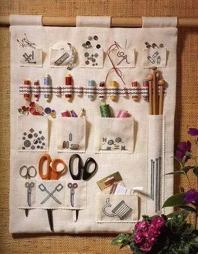 an embroidered wall hanging with scissors and other crafting supplies on it's side